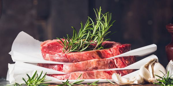 Stack of  raw steaks with rosemary